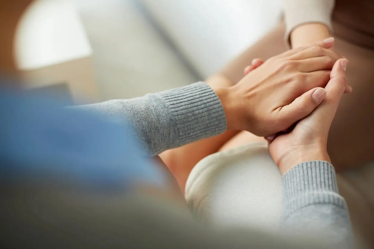 A group of people holding hands on top of a couch.