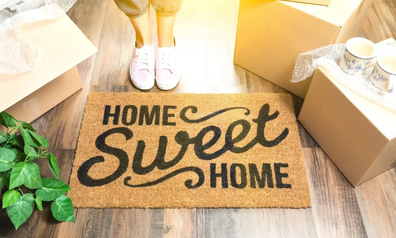 A woman standing on the floor next to a door mat.