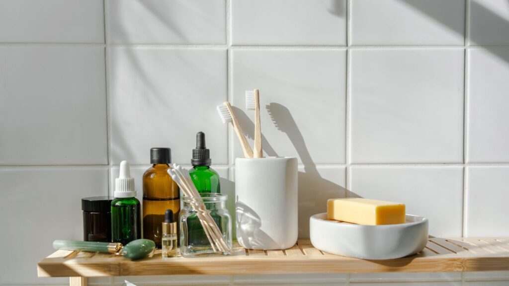 A bathroom counter with toothbrushes, soap and tooth paste.