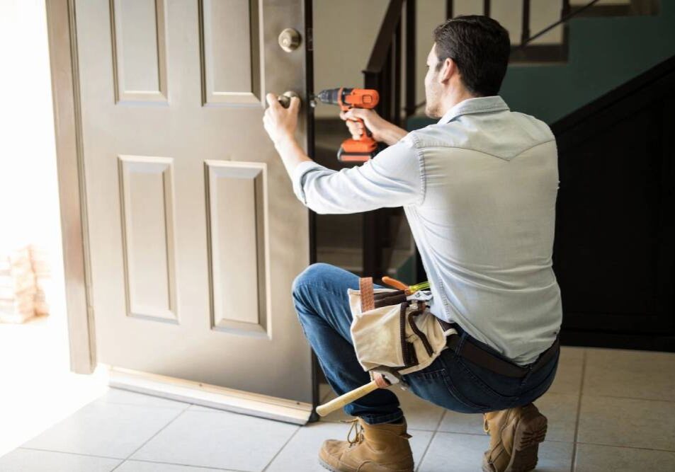 A man is kneeling down and holding tools